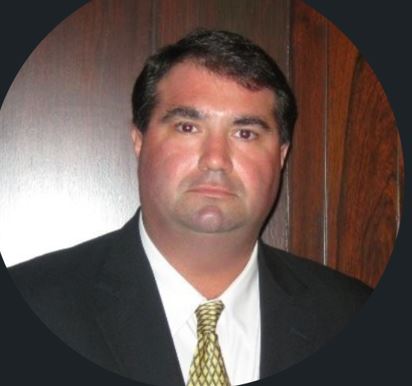 A man in suit and tie standing next to a wall.